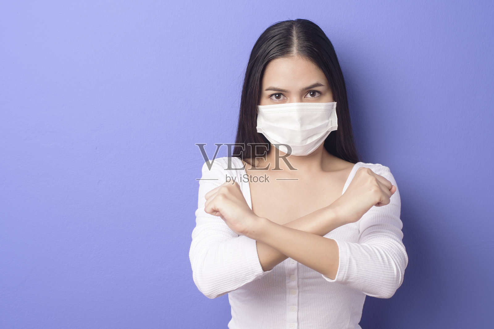 一名年轻女子的肖像是戴着面具在紫色的背景照片摄影图片