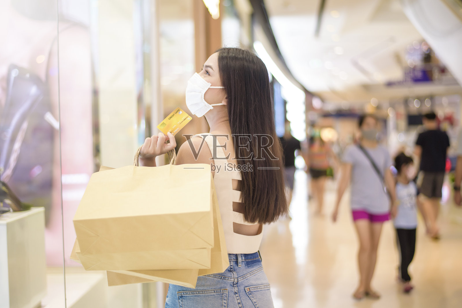 一个美丽的女人的肖像是戴着口罩在购物中心照片摄影图片