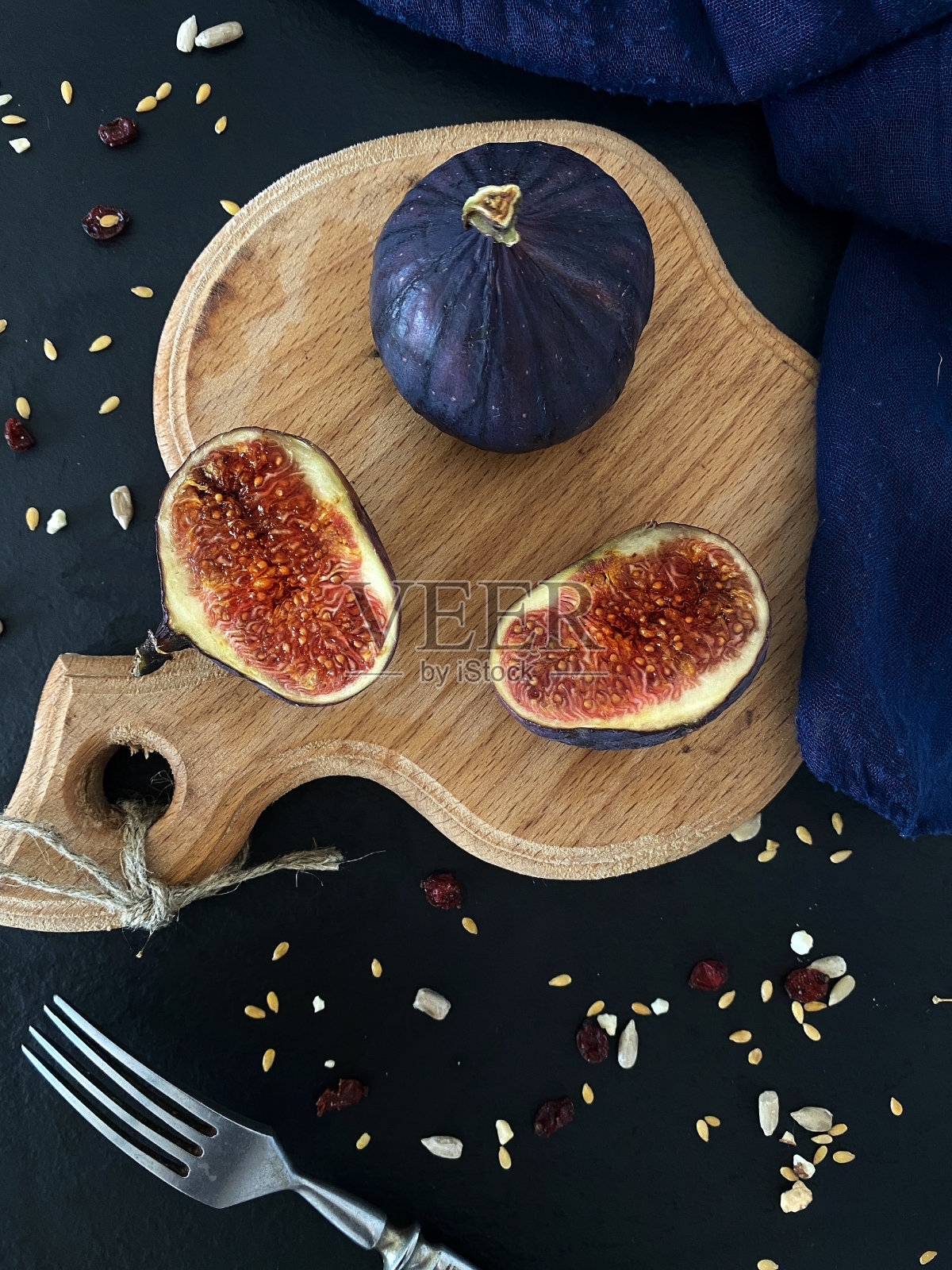 黑色背景上的新鲜无花果。把整个无花果切在木板上。照片摄影图片