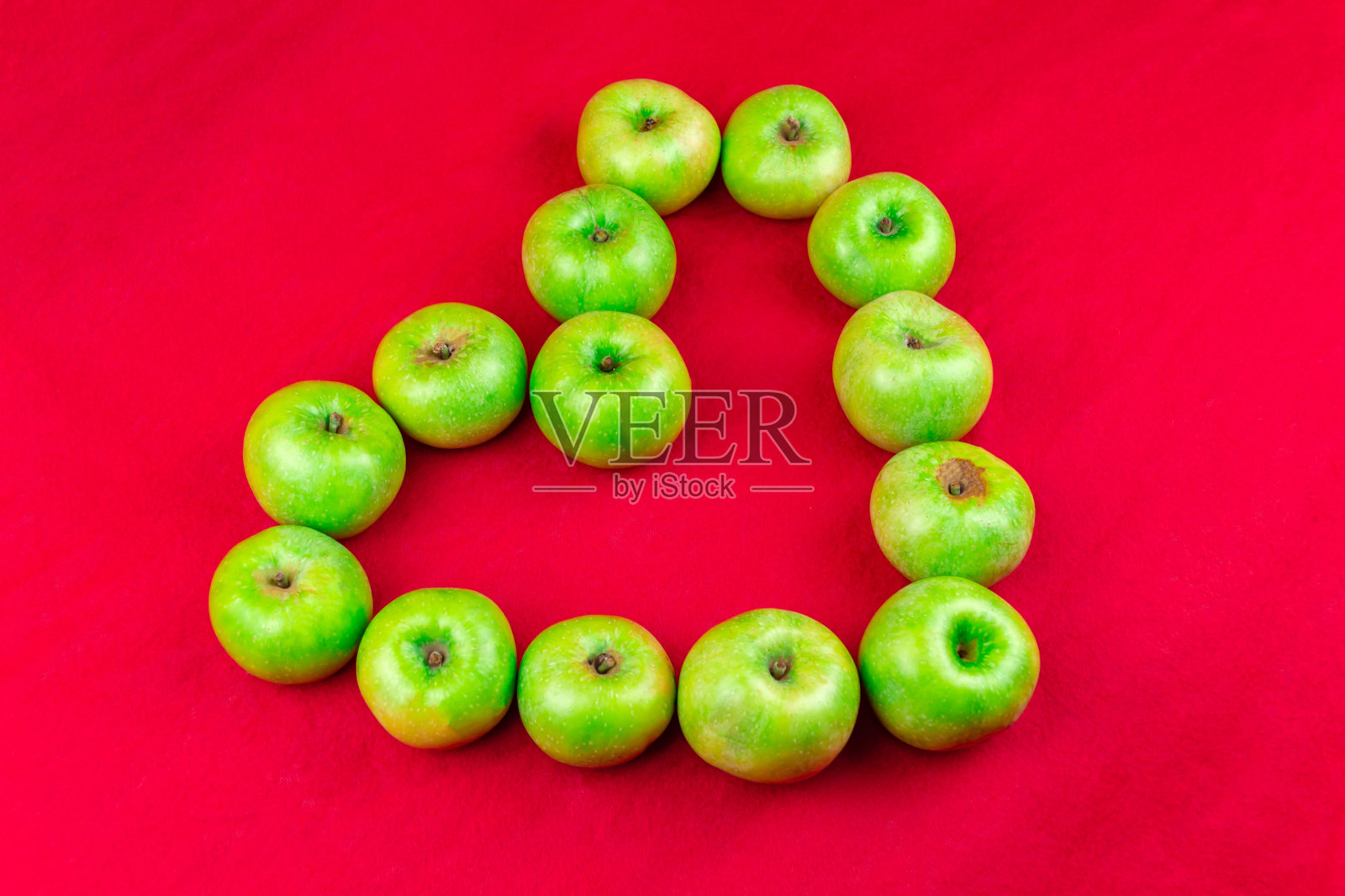 红背景上的青苹果照片摄影图片
