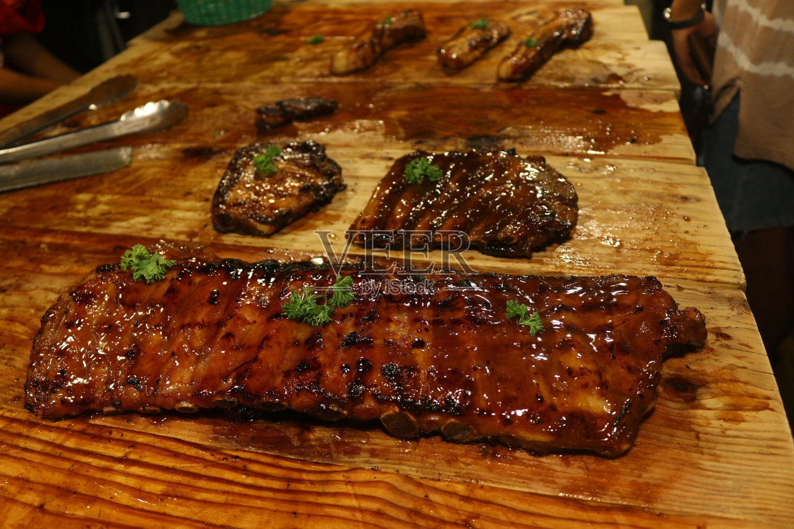 暗棕色烤猪排骨的特写，浅棕色木架上的欧洲美食照片摄影图片