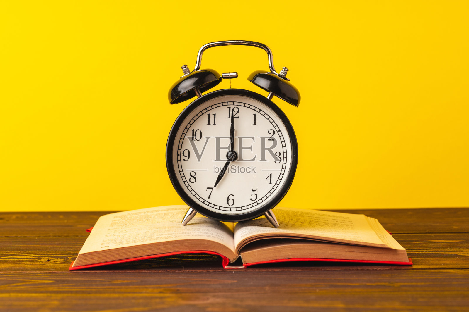 书和闹钟放在桌上，教育理念照片摄影图片