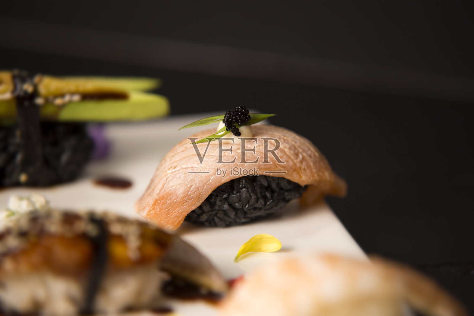 三文鱼清酒Tataki与黑米，蛋黄酱，飞鱼卵(Tobiko鱼子酱)的特写。照片摄影图片