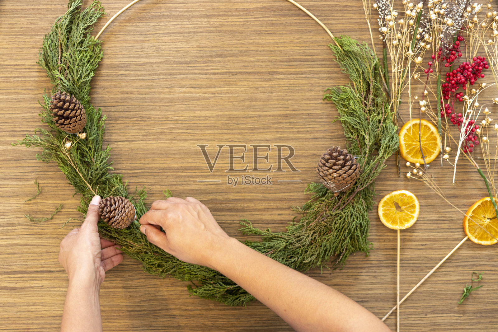 可爱的女人用双手装饰圣诞花环照片摄影图片