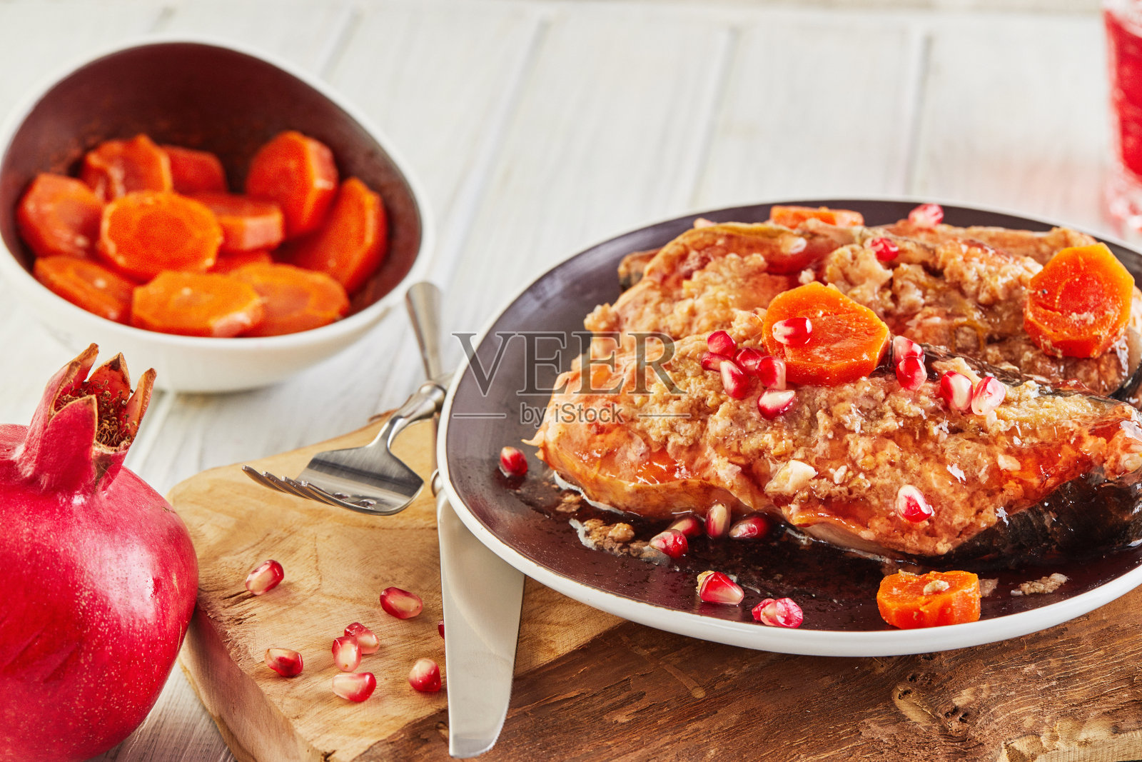 犹太鲤鱼丸配辣根胡萝卜和石榴酒，置于白色木质背景的木板上，一道地道的犹太菜肴照片摄影图片