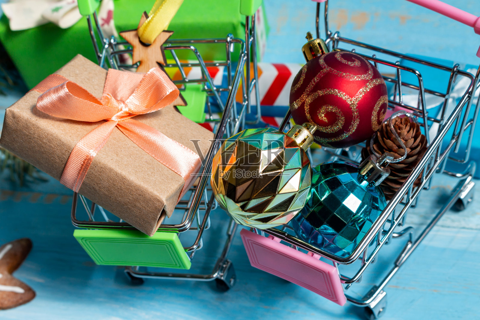 彩色礼品盒在购物车上木制的蓝色背景。为新年和圣诞节做准备的概念。照片摄影图片