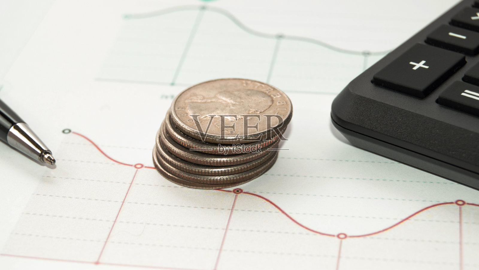 商业和金融概念:堆叠的金币，计算器，笔在图表上照片摄影图片