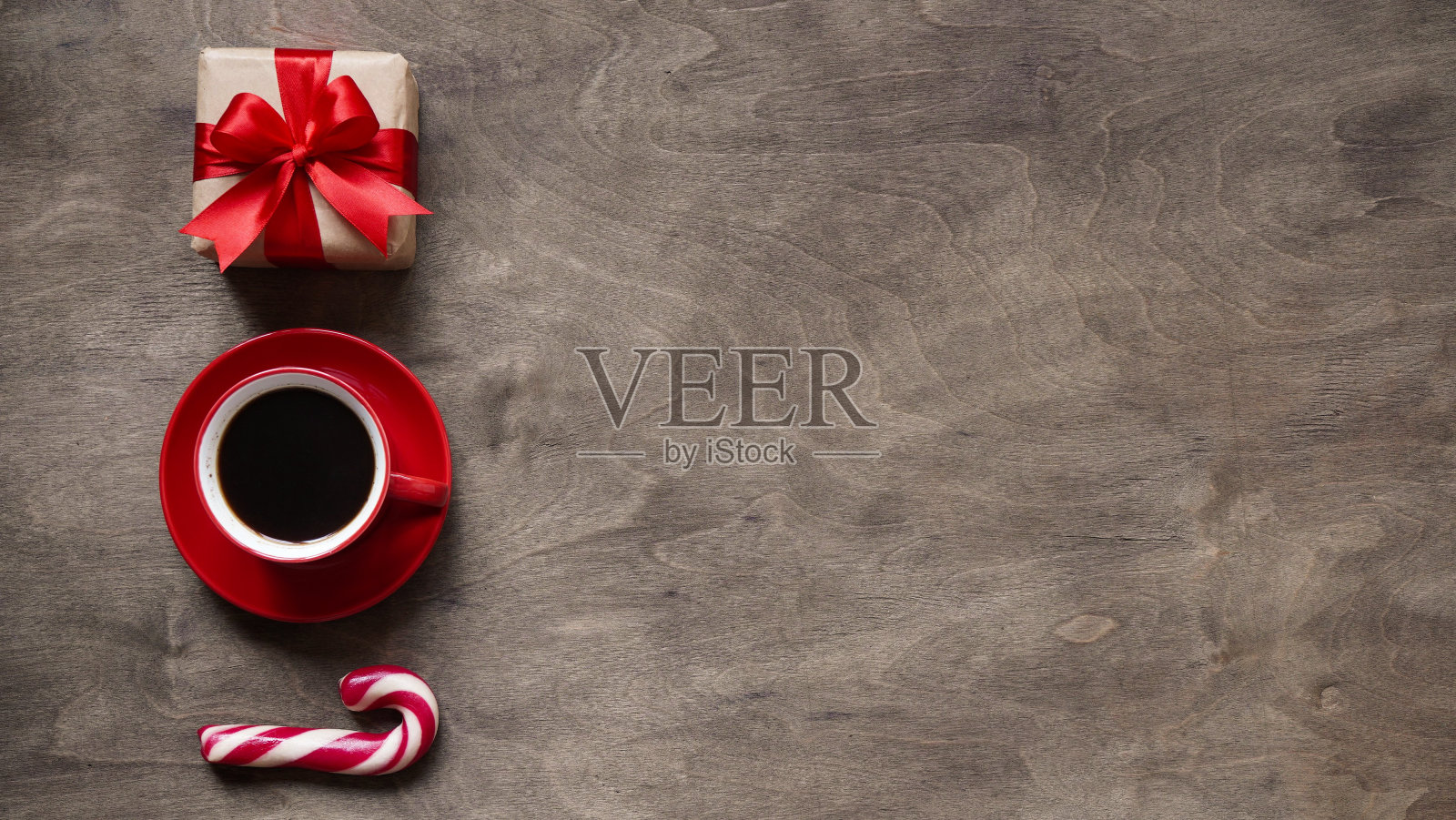 圣诞或新年背景，圣诞装饰礼盒的简单组成，红色杯咖啡和圣诞棒棒糖在棕色的木制背景，平铺，图案，顶部wiev，复制的spaes照片摄影图片