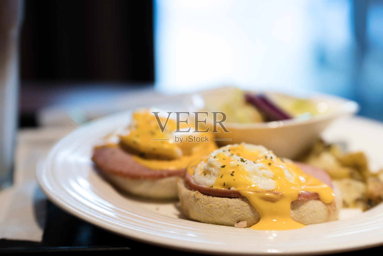 苏格兰周末素食早餐:自制的松饼加两个班尼迪克蛋，配菠菜和黄色荷兰酱。照片摄影图片