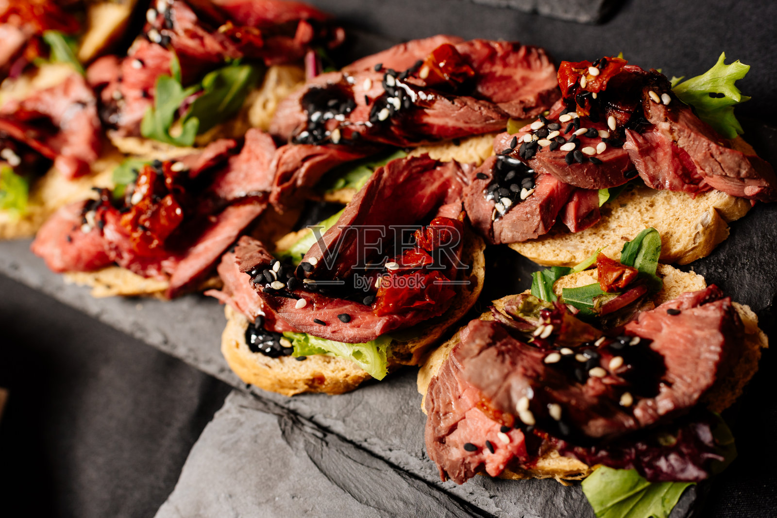 特写美味的意式烤面包放在黑色的桌子上照片摄影图片