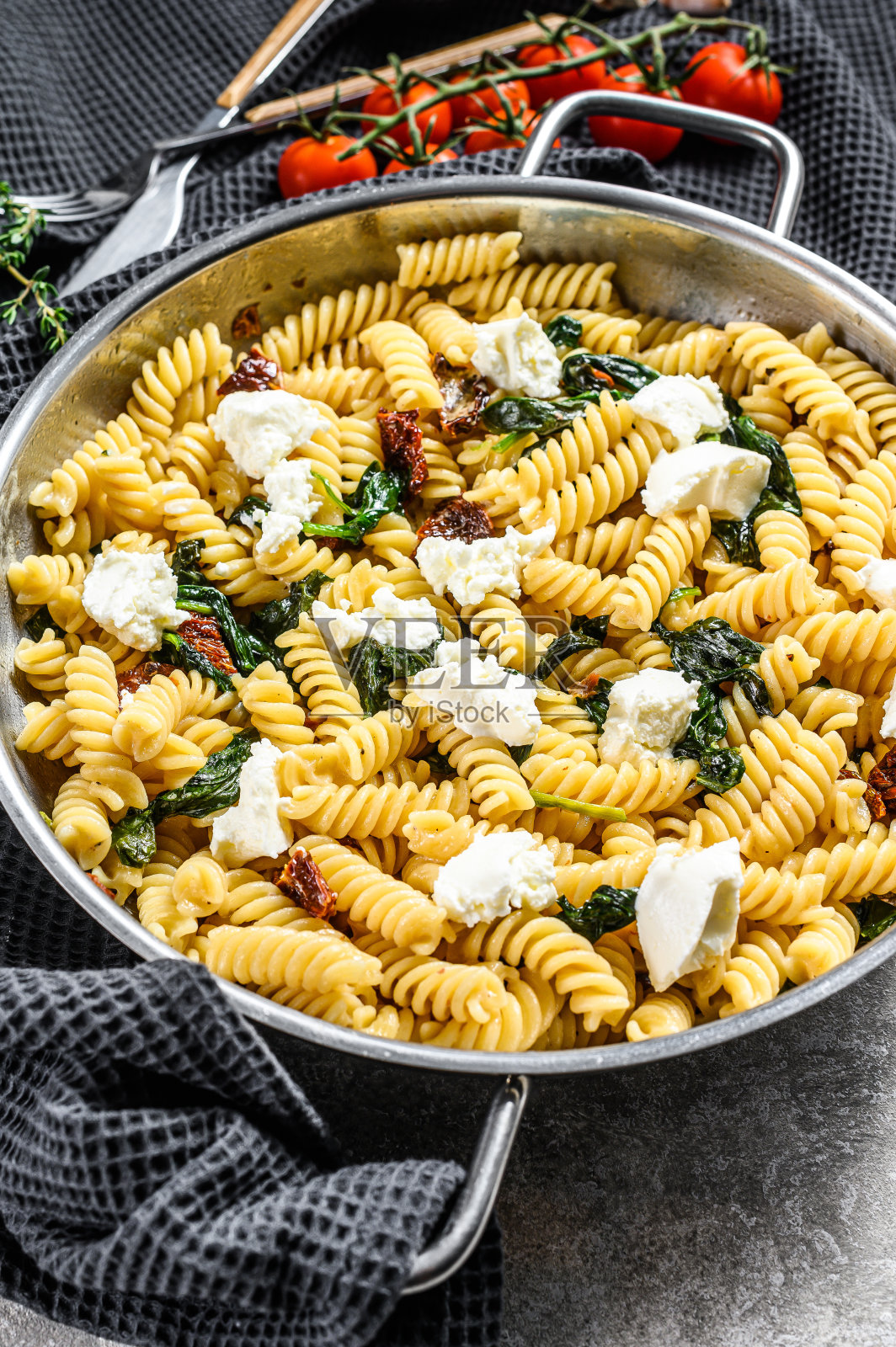平底锅里的菠菜和乳清干酪意大利面。灰色的背景。俯视图照片摄影图片