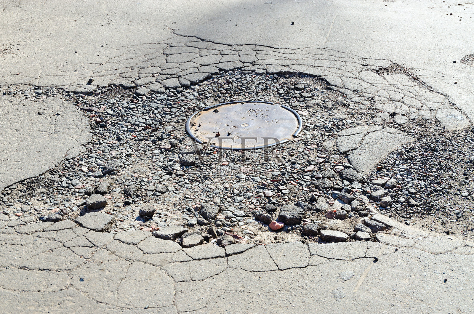 污水舱口周围的沥青路面被破坏照片摄影图片