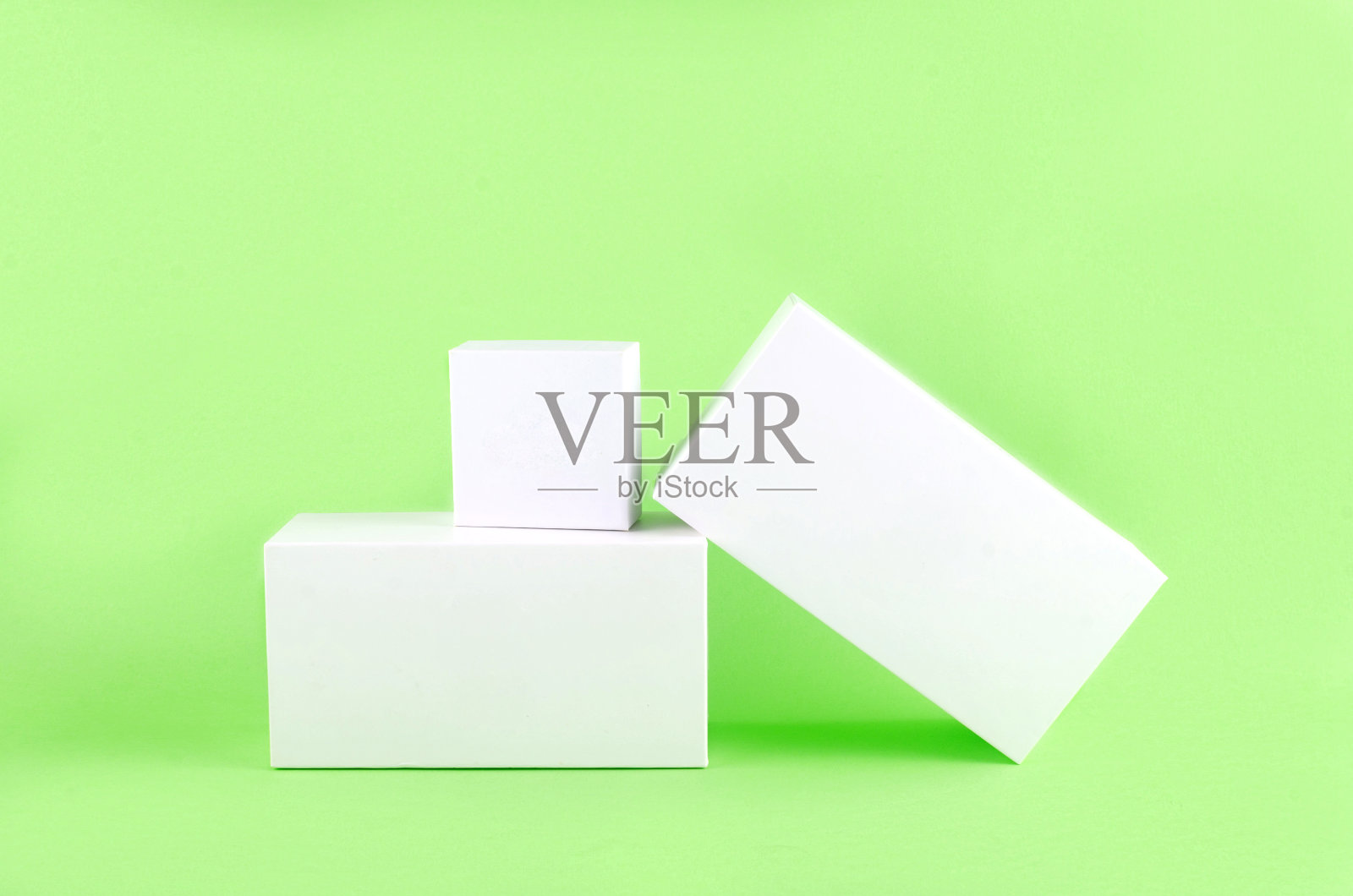 三个白色几何图形，一个浅绿色背景上有阴影的矩形。照片摄影图片