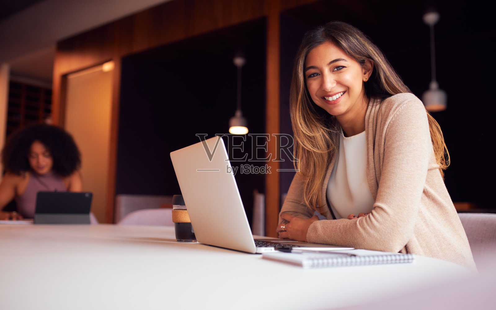 在健康大流行期间，商务女性在办公室社交距离会议上使用笔记本电脑的肖像照片摄影图片