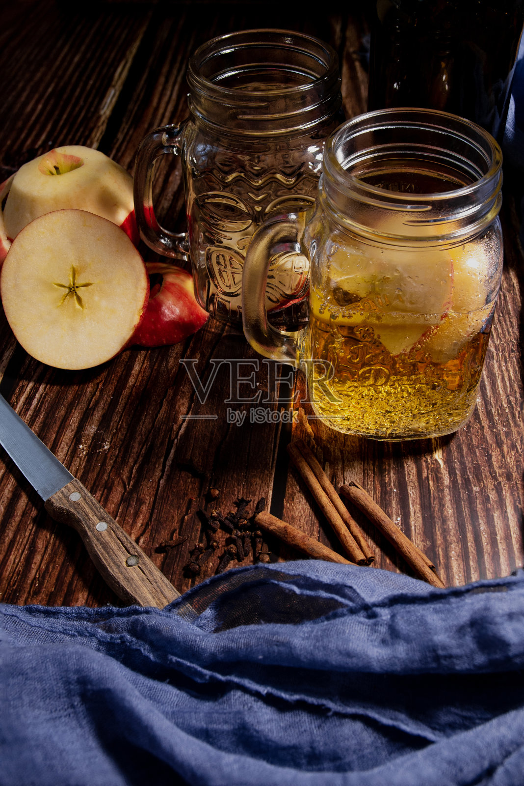 天顶平面的木桌上放着苹果和可口的苹果酒。典型的秋季喝照片摄影图片
