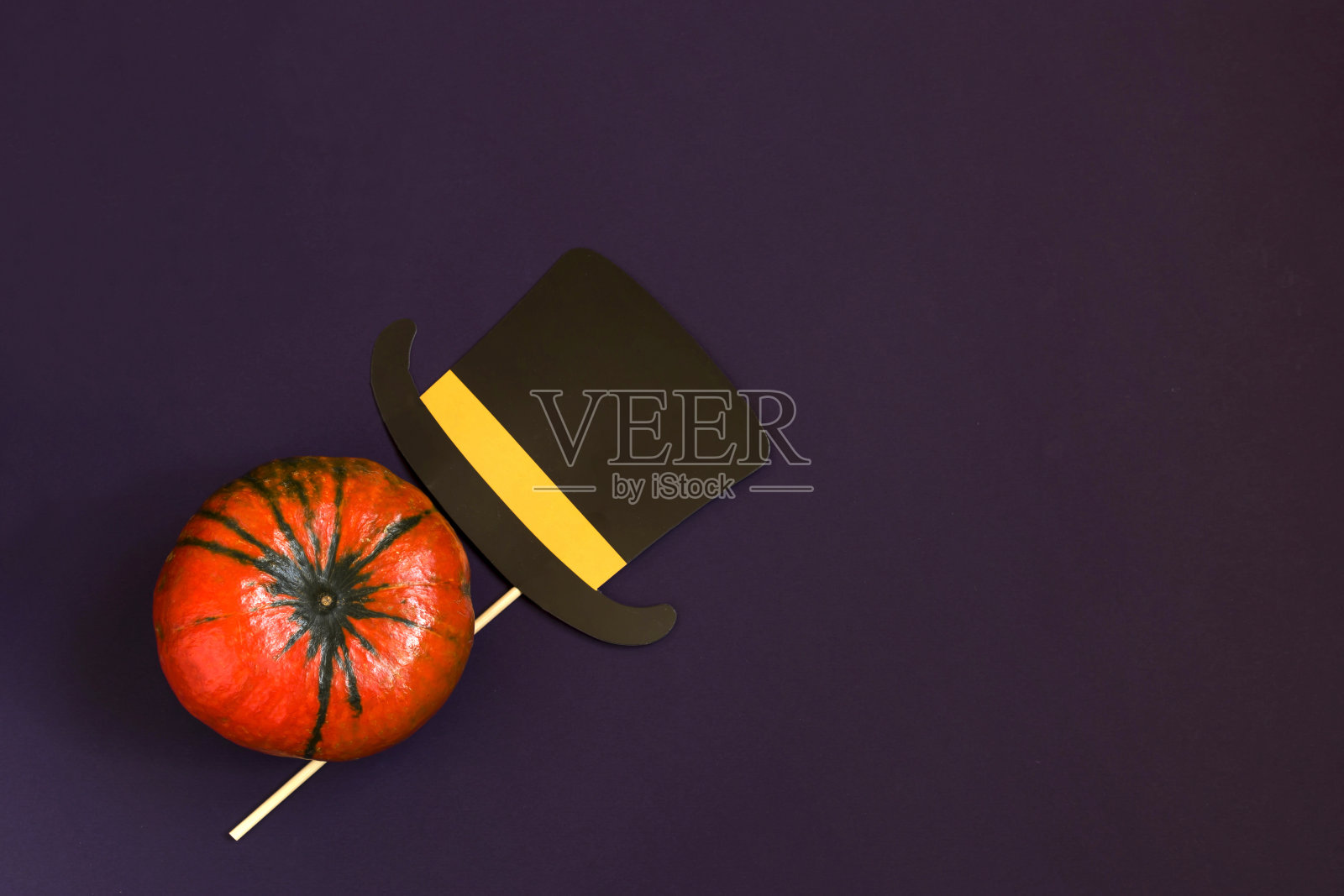 万圣节快乐的文字在木制的字母，南瓜在黑色的背景，纸帽子，平躺。大气的形象。秋天的明信片。副本的空间。照片摄影图片