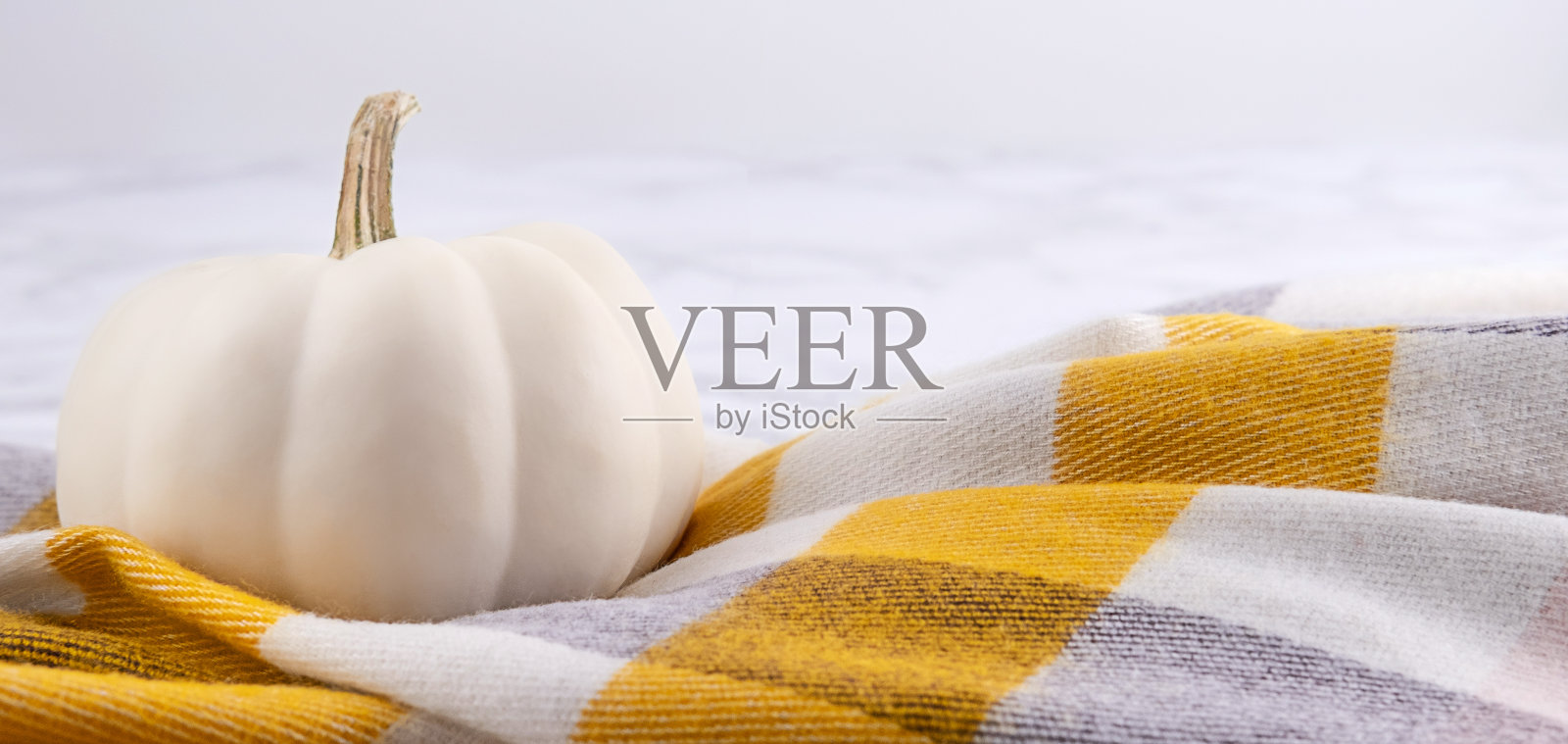 大理石背景上的白色南瓜围巾。照片摄影图片