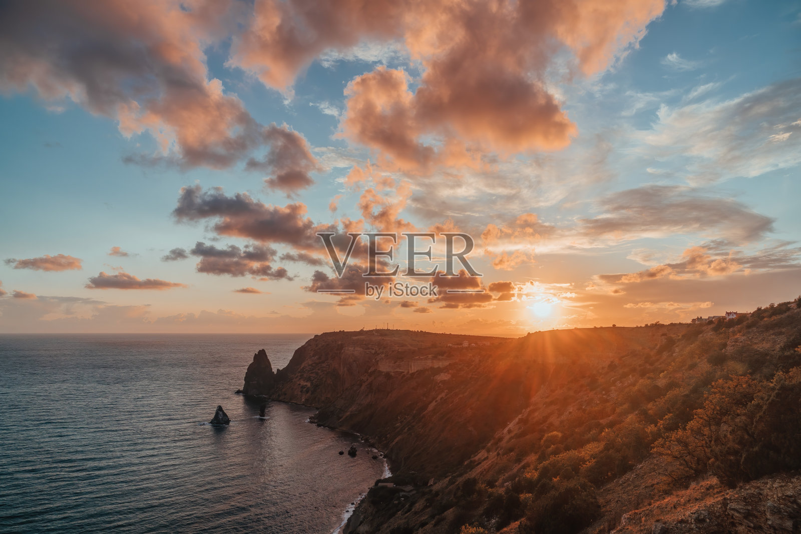 秋天的海景与温暖的日落光在岩石海岸。平静的海面，岩石海岸的背景。是秋季旅游和休息的理想去处。大自然永无止境的美丽照片摄影图片