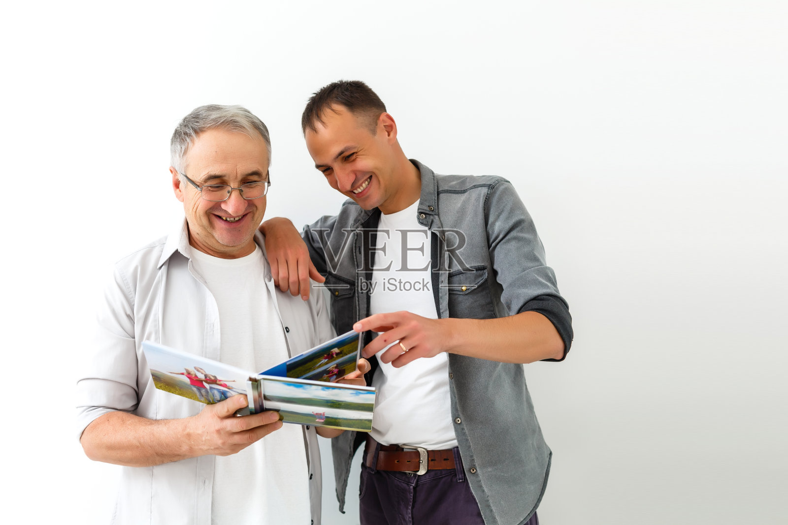 父亲和儿子在看他们度假的照片照片摄影图片