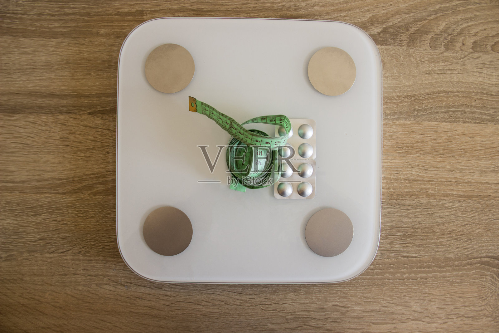 卷尺和减肥药躺在白色的东西上照片摄影图片