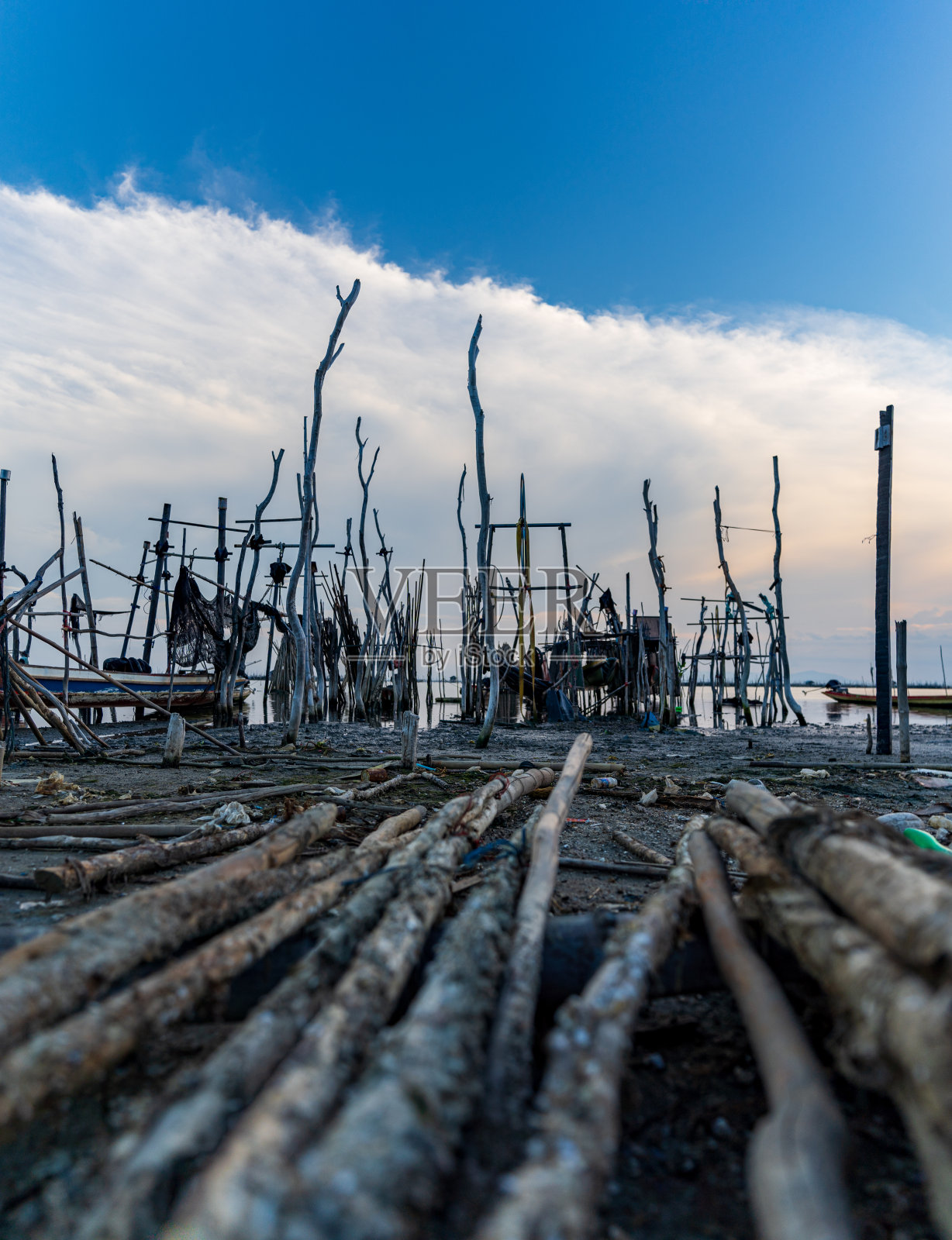 在不当班时，一条长尾船被放在艇架上。船东应将其船从网架上取下放入泻湖，以喂鱼或修理设备。这个渔村位于泰国南部的宋卡照片摄影图片