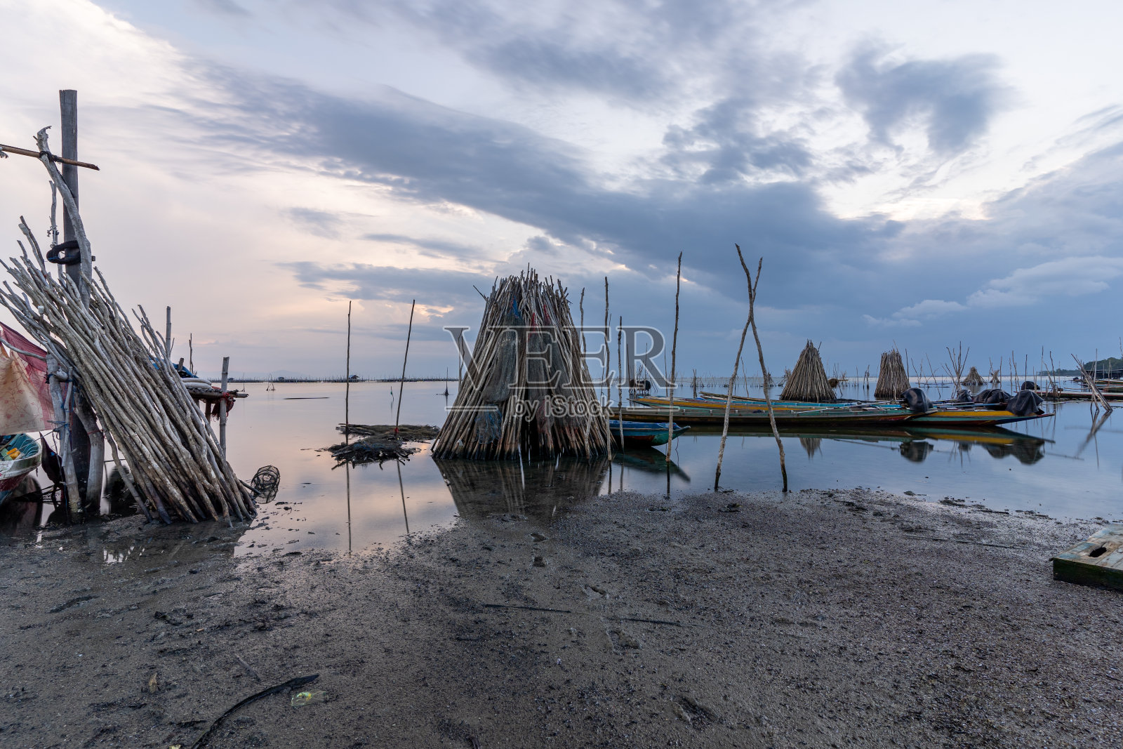 在不当班时，一条长尾船被放在艇架上。船东应将其船从网架上取下放入泻湖，以喂鱼或修理设备。这个渔村位于泰国南部的宋卡照片摄影图片