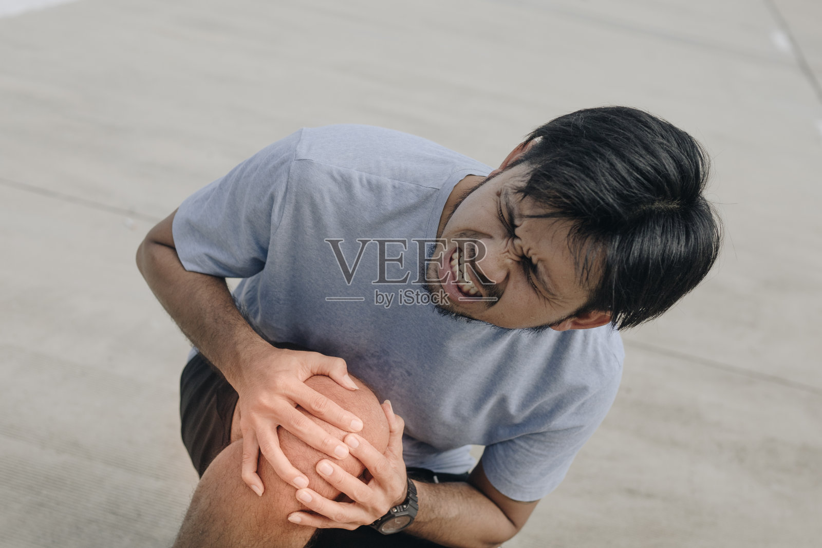 年轻的亚洲人感觉膝盖疼痛照片摄影图片