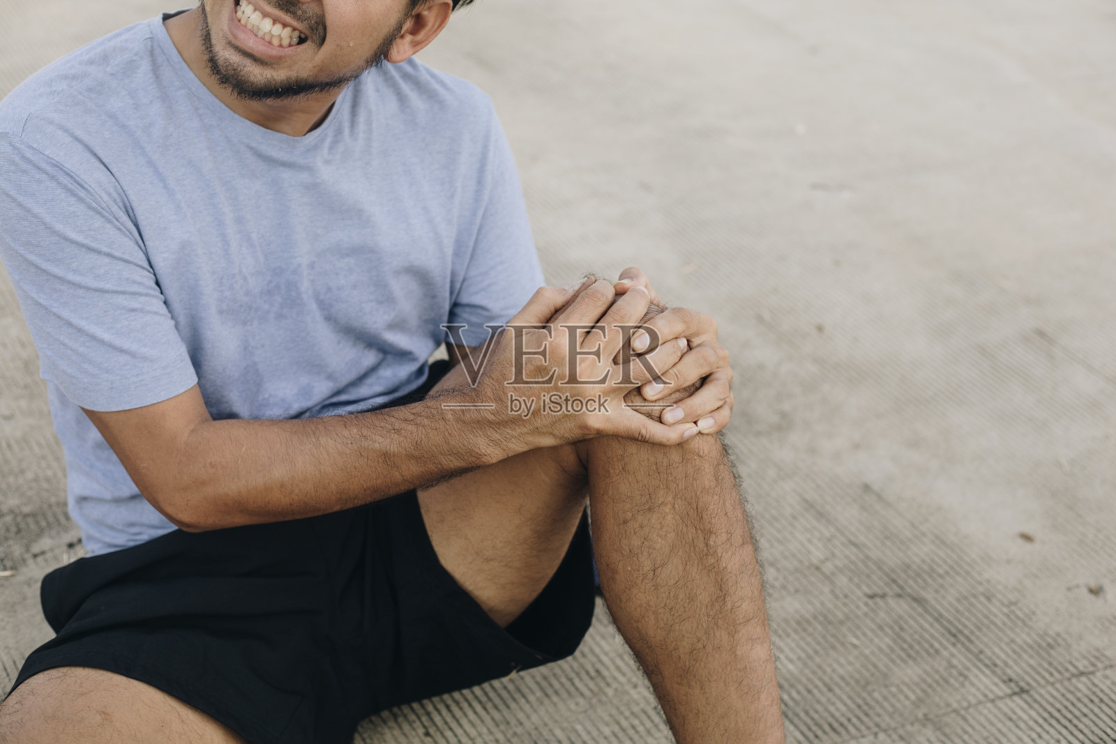 年轻的亚洲人感觉膝盖疼痛照片摄影图片