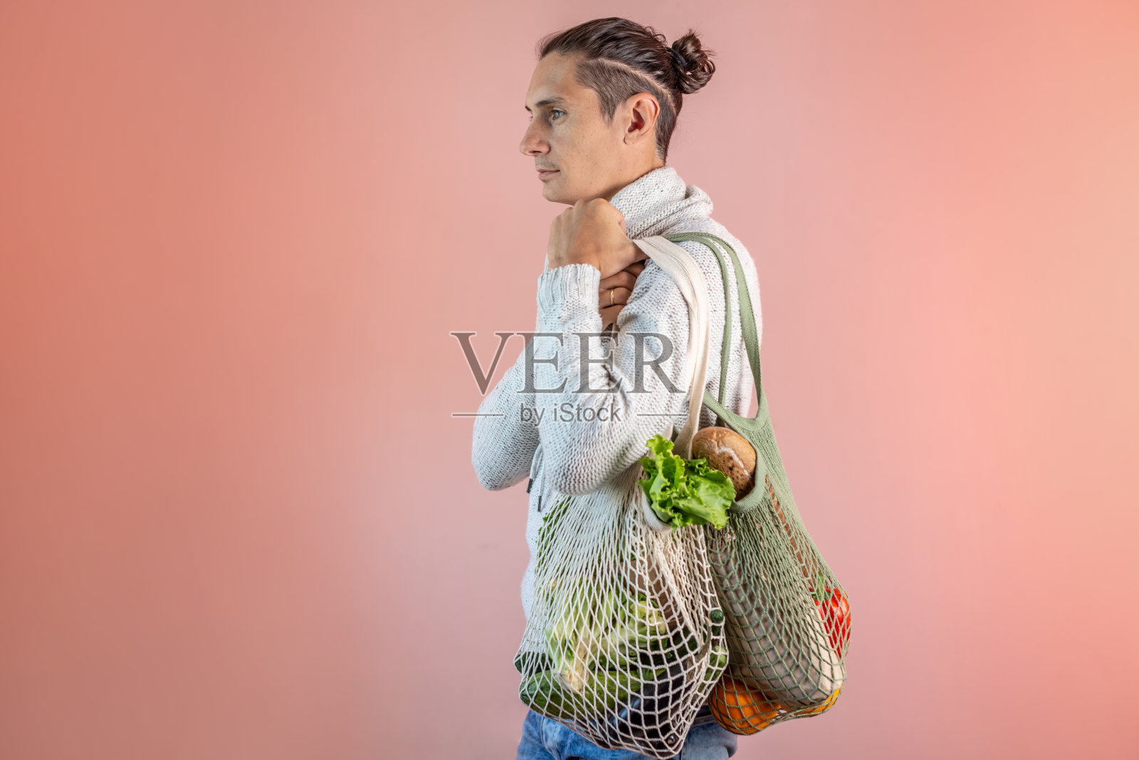 现代的年轻人拿着一个装着商品的网袋。环保的行为理念，使用可重复使用的袋子和关心环境照片摄影图片