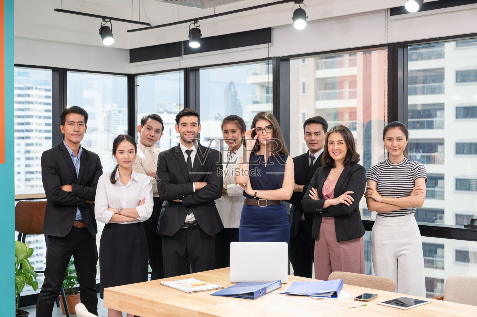 多民族自信的商业集团在现代化的办公室里交叉手臂照片摄影图片