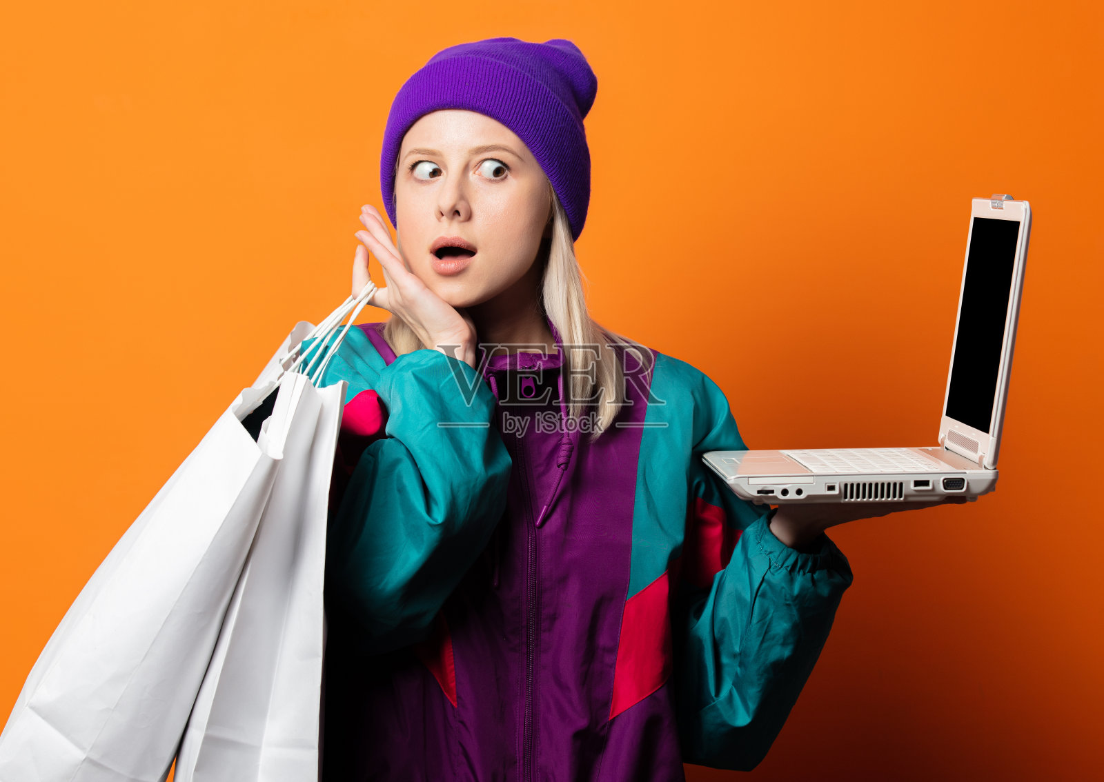 穿着90年代的运动服，带着笔记本和购物袋的时尚女士照片摄影图片