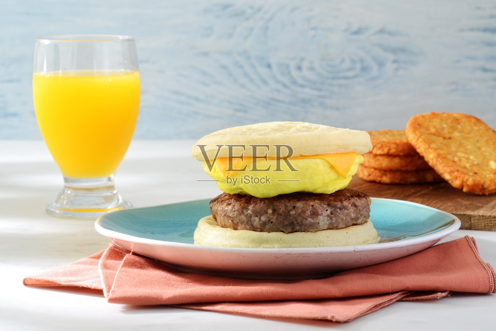 香肠，鸡蛋，奶酪，华夫三明治，还有一杯橙汁照片摄影图片