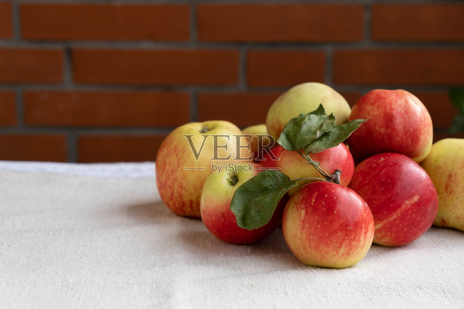 桌上铺着一块台布，上面放着成熟多汁的苹果照片摄影图片
