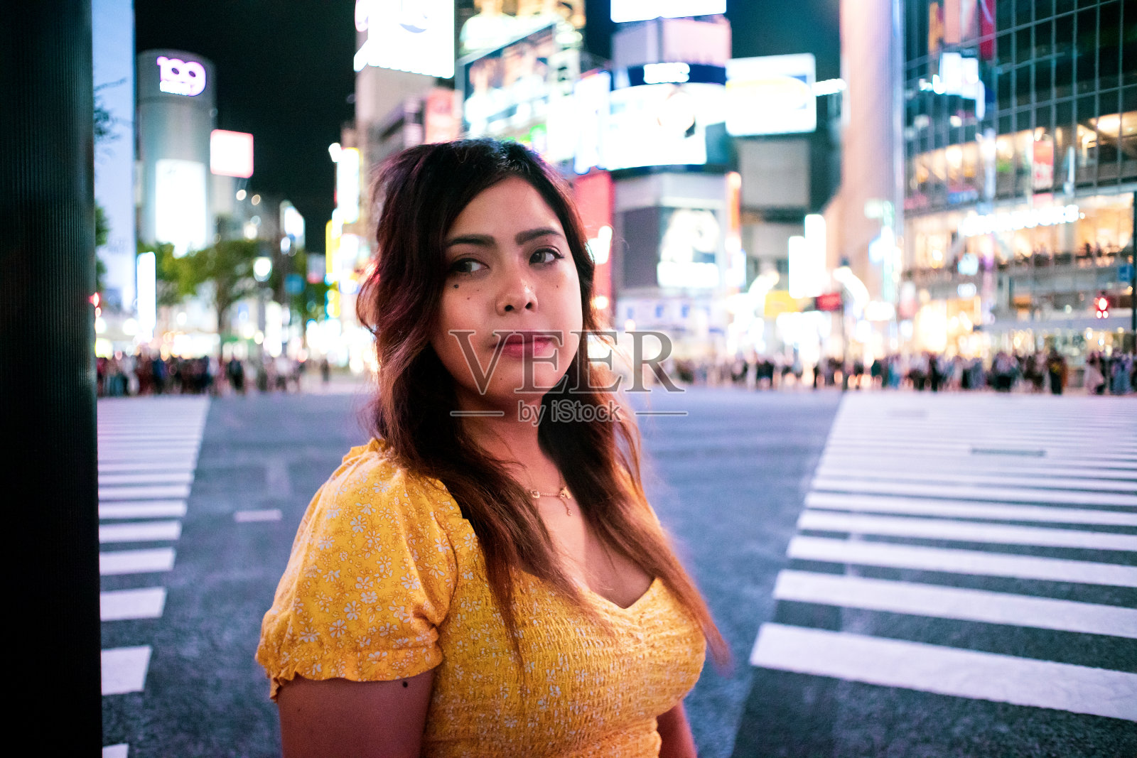 年轻女子在东京涩谷十字路口的夜景肖像照片摄影图片