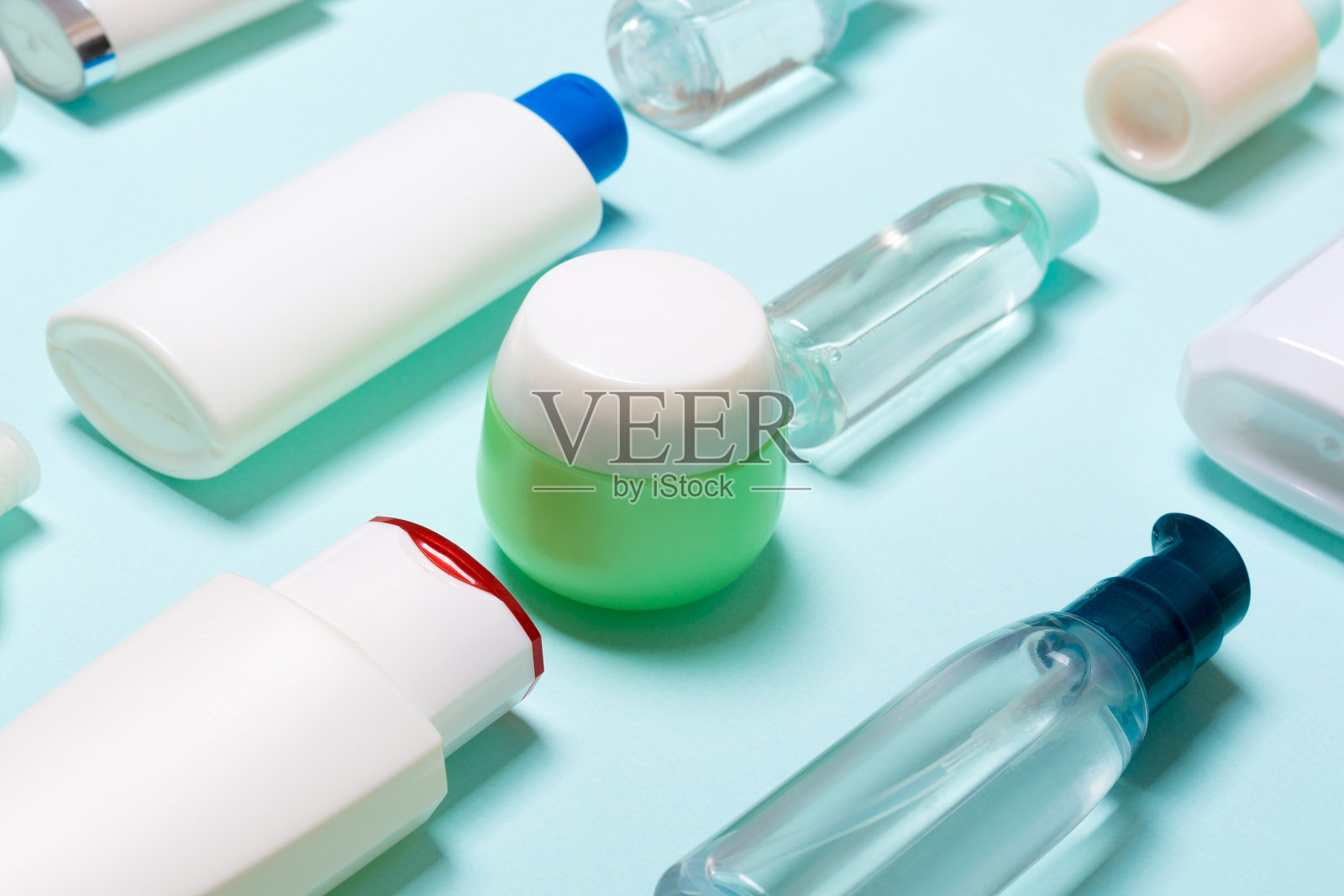 特写设置不同大小的瓶子和罐子化妆品上的蓝色背景。面部和身体护理概念与复制空间照片摄影图片