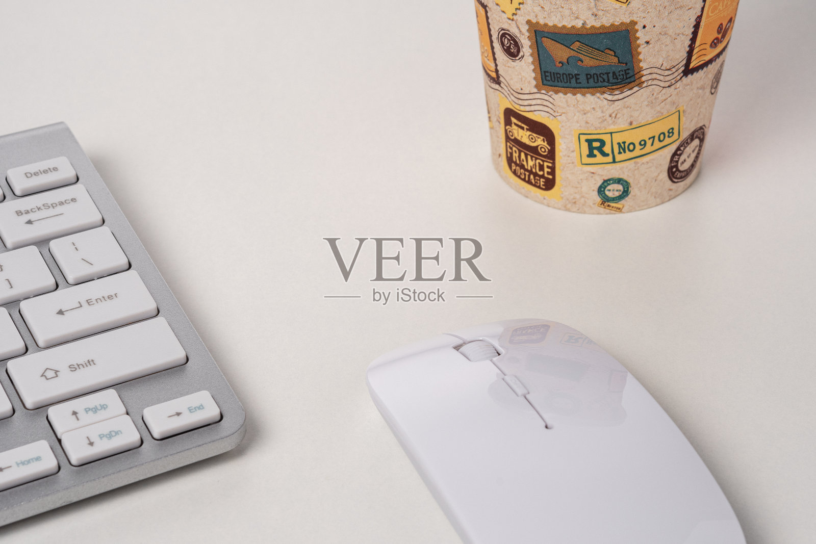 键盘和鼠标的现代电脑与一个咖啡杯。照片摄影图片