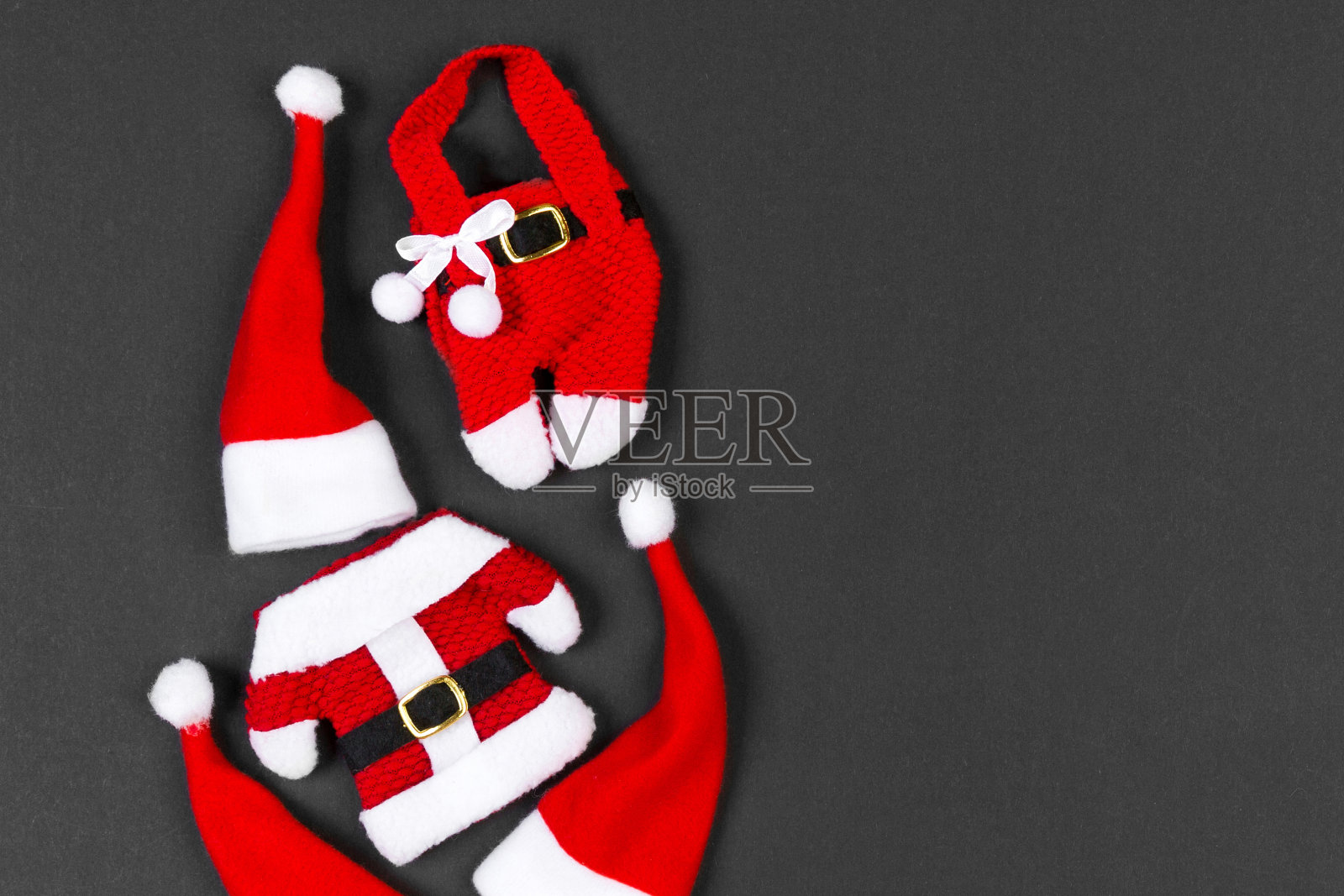 由圣诞帽和衣服制成的节日彩色背景俯视图，带有复制空间的圣诞节概念照片摄影图片