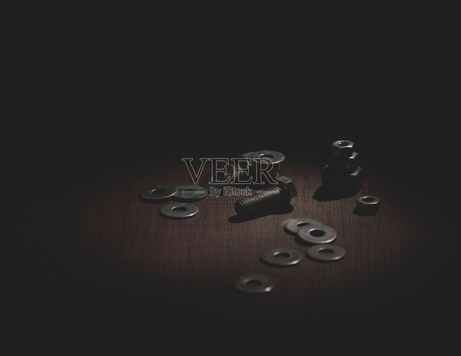 螺栓，螺母和金属垫圈的特写在一个黑暗的设置木质表面照片摄影图片