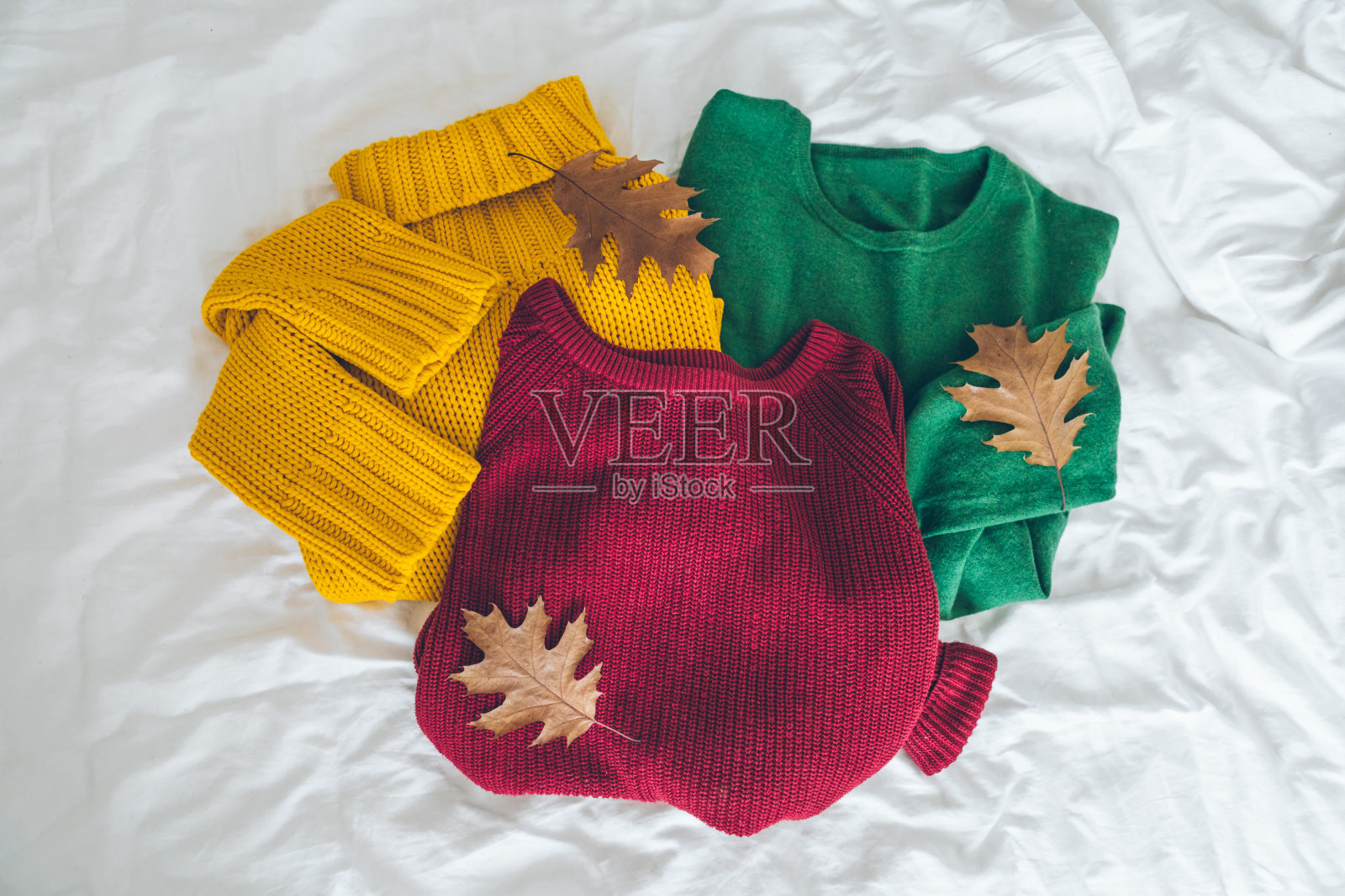 白色床单上五颜六色的毛衣照片摄影图片