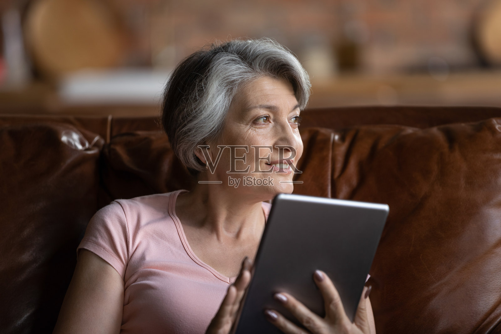 微笑的妇女使用平板电脑在家放松照片摄影图片