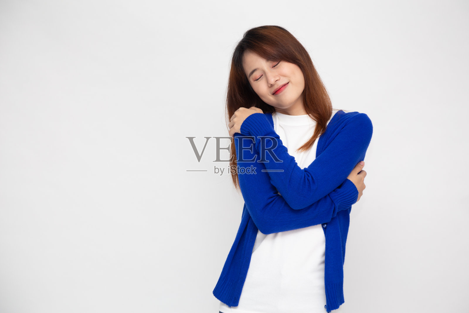 快乐年轻随意的亚洲女人拥抱自己孤立的白色背景。爱自己的概念照片摄影图片