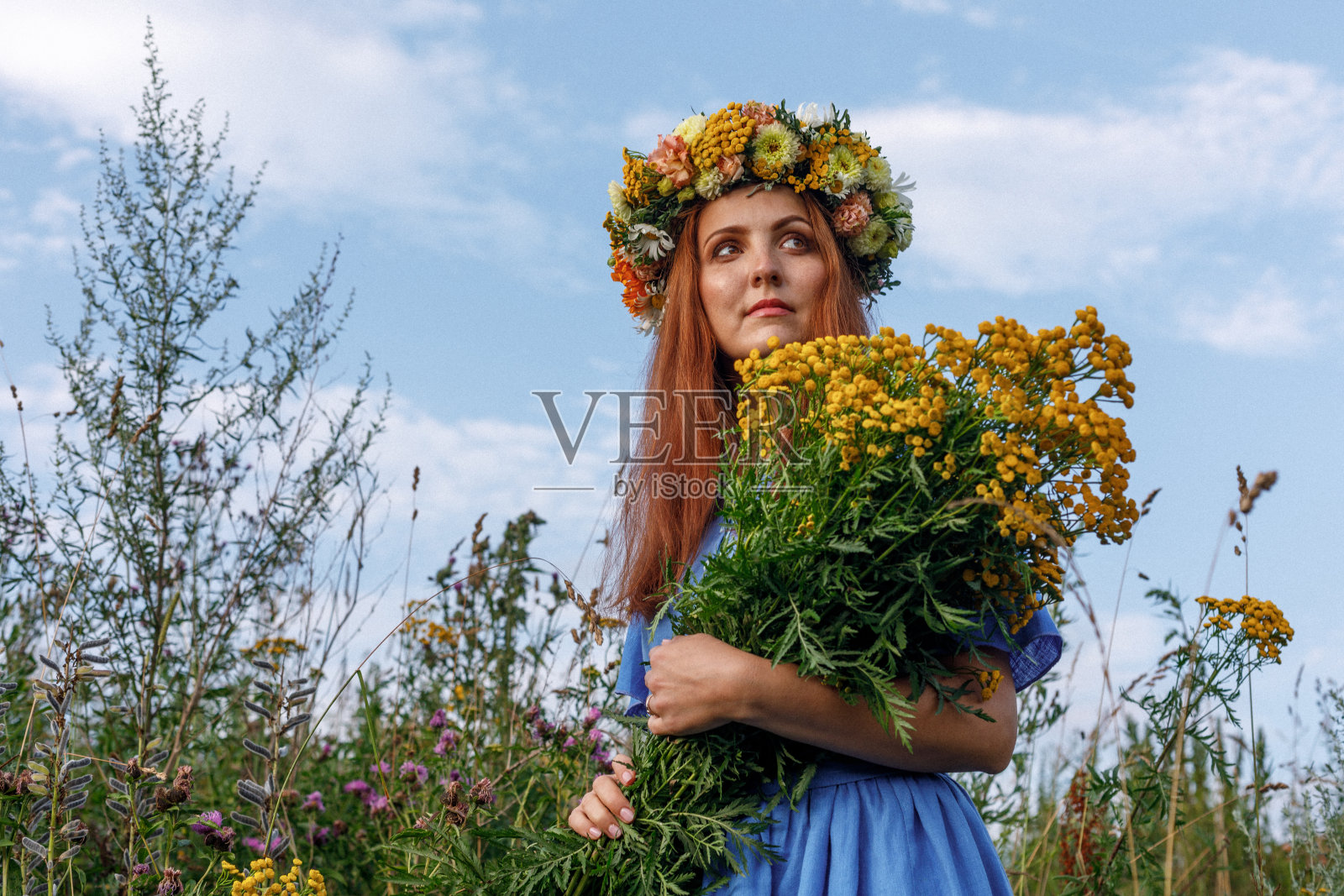斯拉夫美人，头上戴花圈和一束野花。古代异教起源的庆祝概念。夏至日。中期的夏天。古老的仪式。照片摄影图片