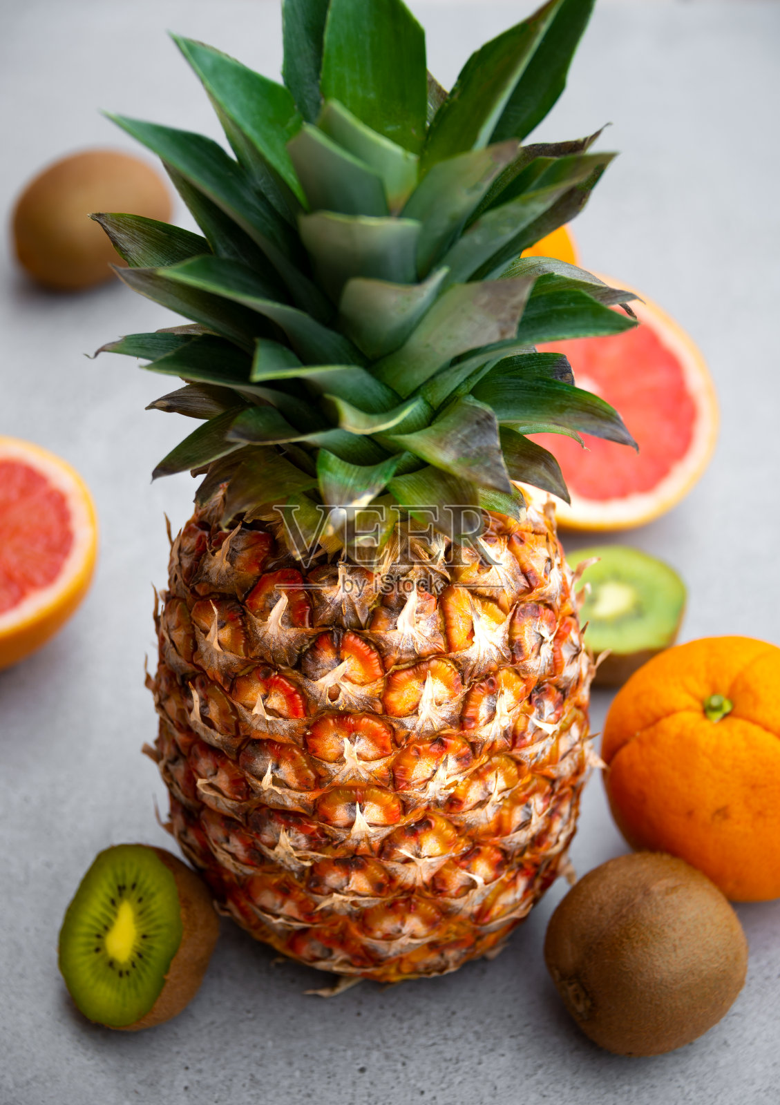 成熟的菠萝和其他热带水果-橙，猕猴桃，葡萄柚灰色背景照片摄影图片