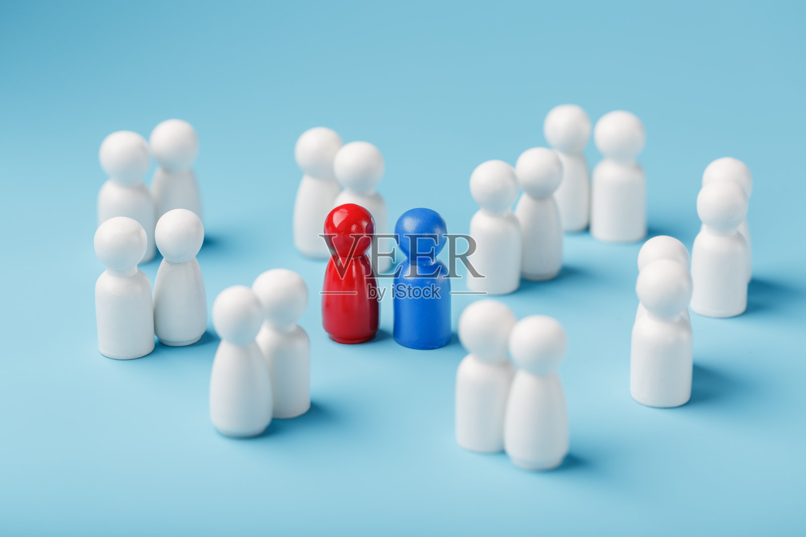 为了爱情而选择性伴侣，从这样一群单调的人中选择恋爱关系。一群白人中有一个红女人和一个蓝男人。照片摄影图片