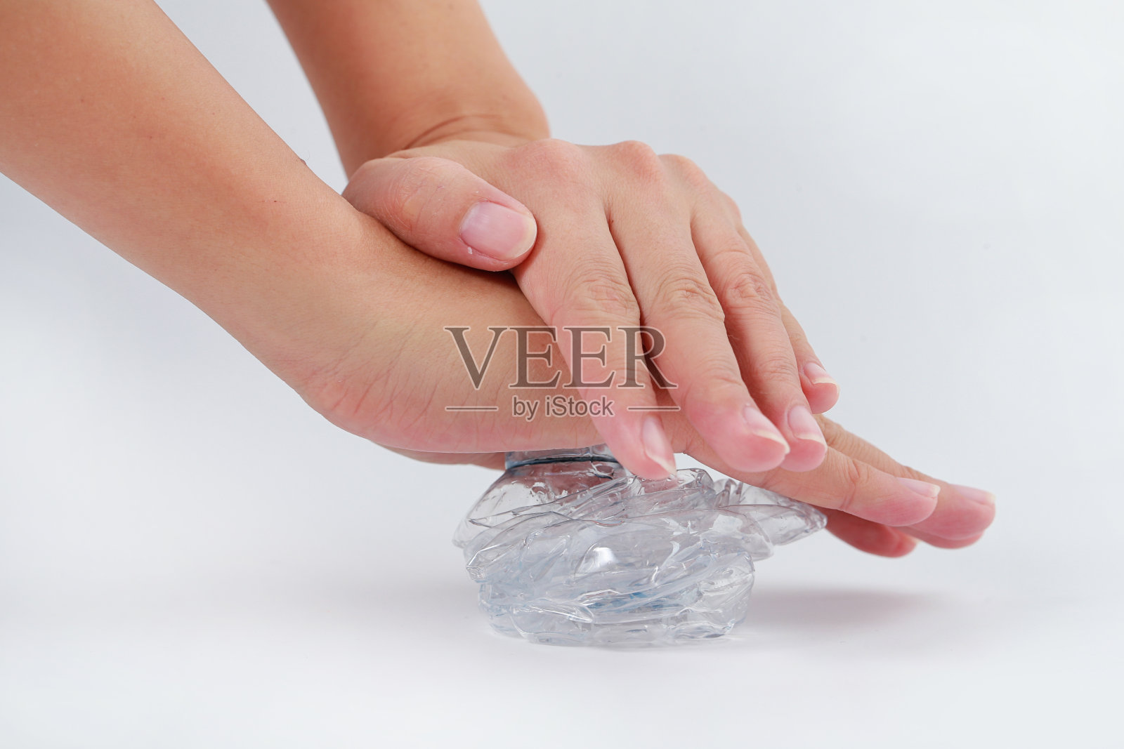 裁剪图像人的手压碎一个塑料饮料瓶照片摄影图片