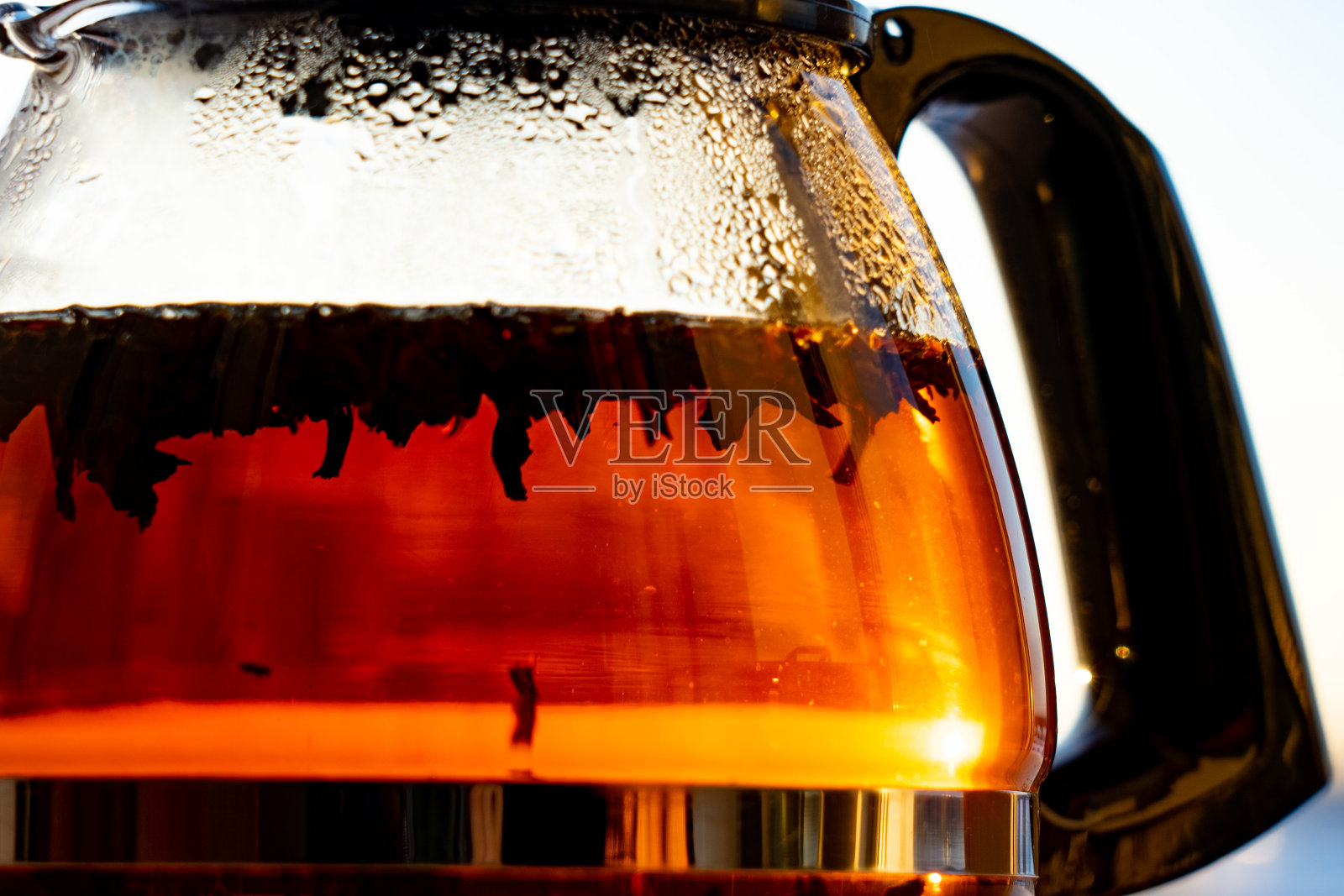 早晨阳光下用透明玻璃制成的茶壶照片摄影图片