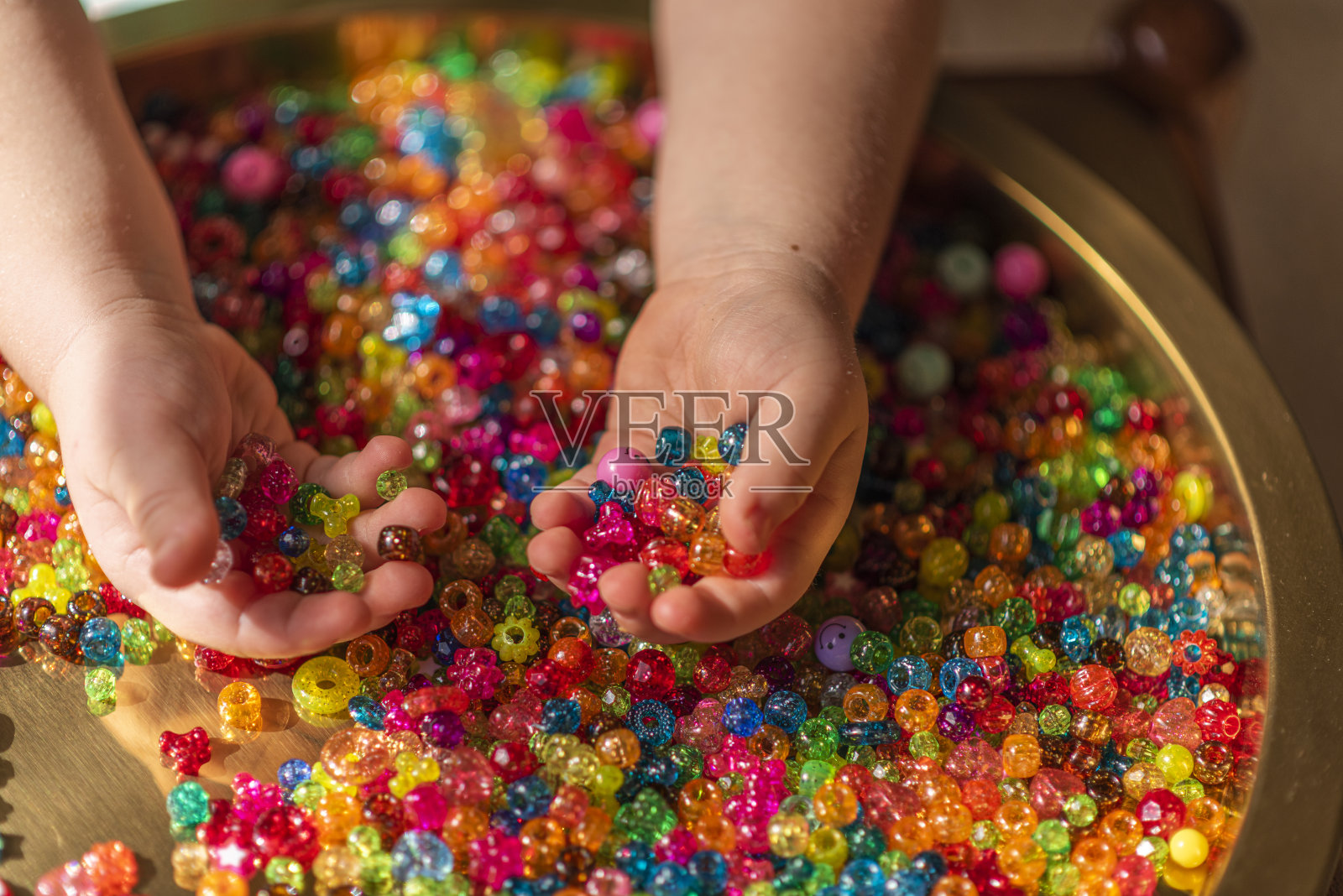 女孩的手拿着彩色心形珠子照片摄影图片