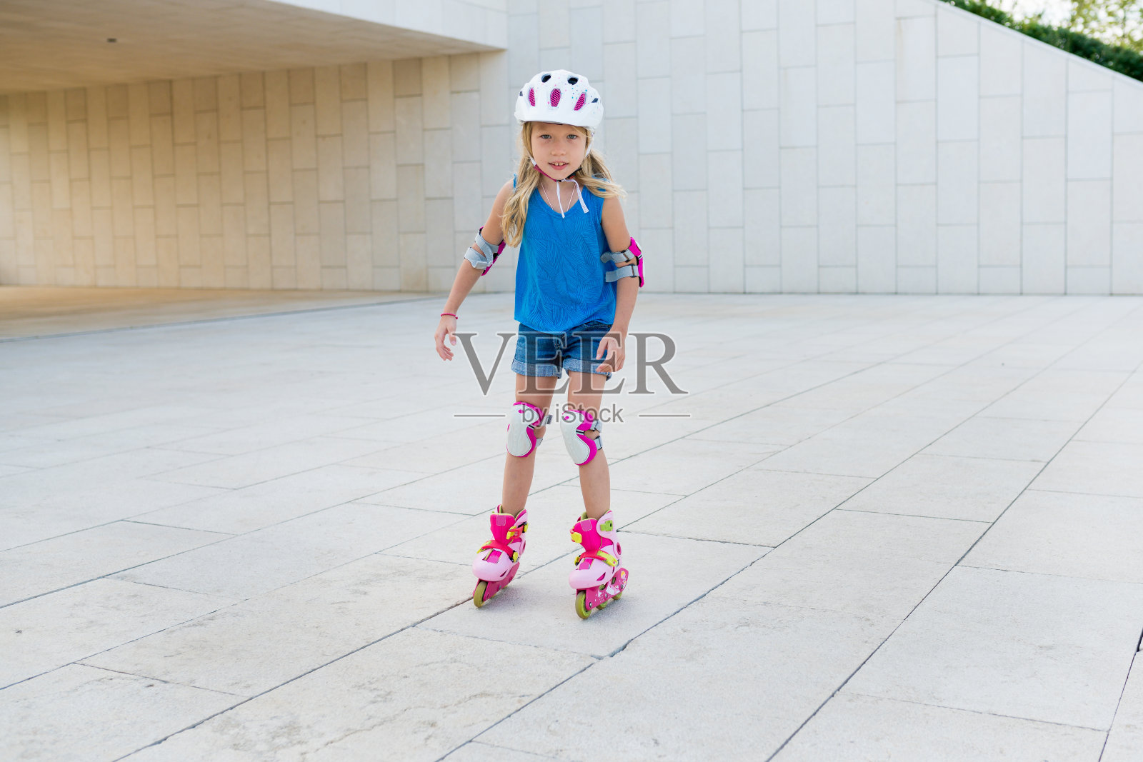 可爱的女孩在阳光明媚的日子里在公园里学习骑旱冰鞋。孩子在外面玩。儿童积极健康的休闲和户外运动照片摄影图片