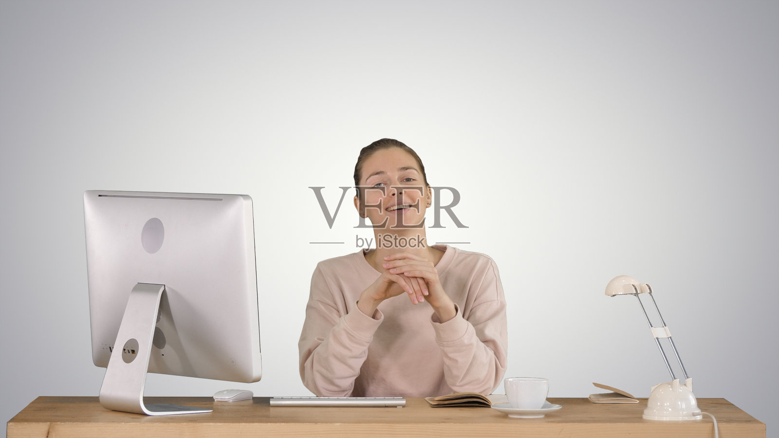 微笑的千禧一代女性坐在桌前，对着镜头说话照片摄影图片