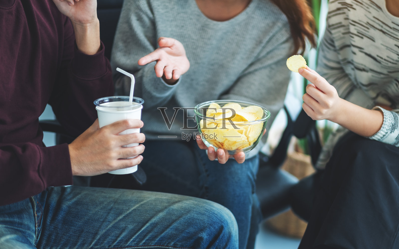 朋友们一起喝着吃着薯片照片摄影图片